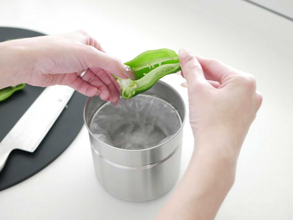密閉できる生ゴミキャニスターと野菜や調理器具がキッチンに配置されている