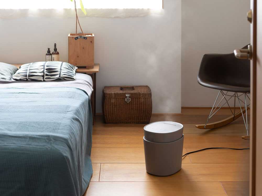 木製フローリングに家具やスツール、ランプが配置された室内