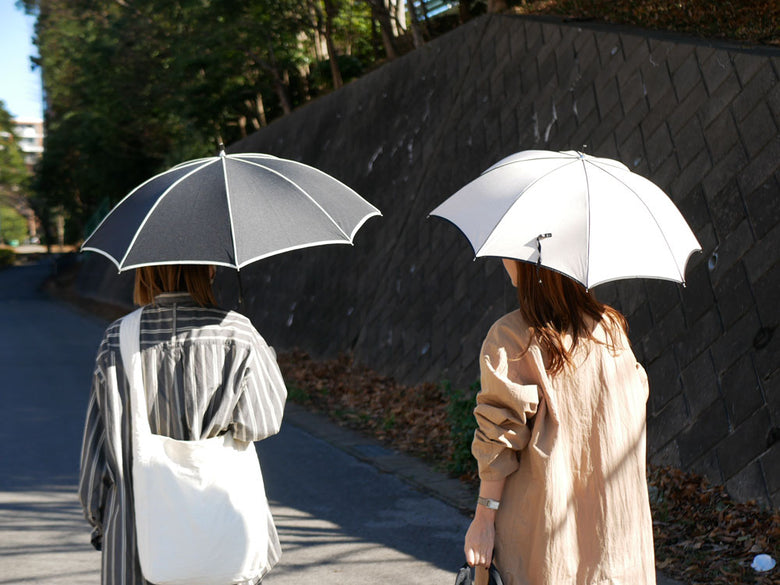 ビコーズ プレーンパイピング グレーの晴雨兼用傘。防水・UVカット加工のポリエステル生地、ラタンとレザーのハンドル、手開きタイプでセーフガード付き。