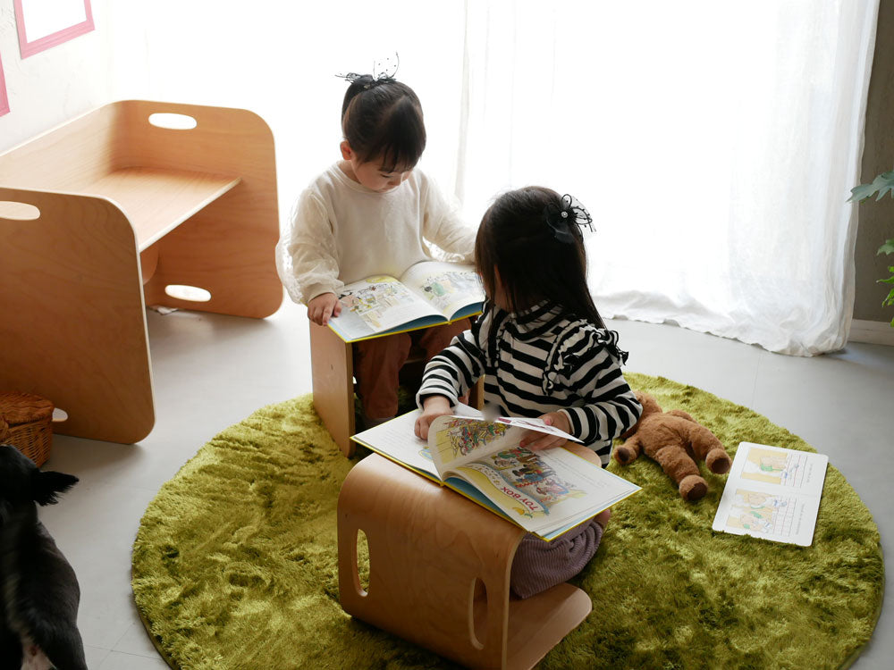 リビングルームに配置されたホップルの直径130cm円形ラグの上で幼児が遊んでいる様子