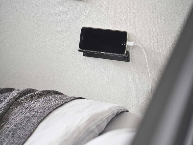 シルバー色のスチール製【tower/タワー】ウォールスマートフォンホルダーが壁にしっかりと取り付けられている様子