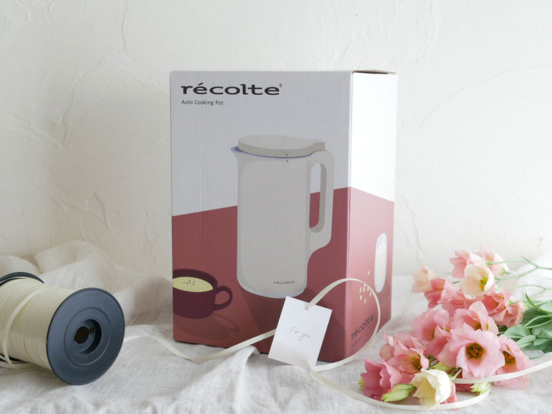 【recolte】自動調理ポット本体とフタ、計量スプーン、お手入れブラシがキッチンテーブルに並べられている様子