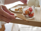 フリッツ・ハンセンのSkagerak Norr Tray。オークとレザー製のトレイ上に食器やカトラリー、調理器具が美しく配置されています