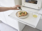 tower/タワーのキッチン家電下スライドテーブルが設置されたキッチンカウンターに、食器や小型家電が整然と並んでいる様子