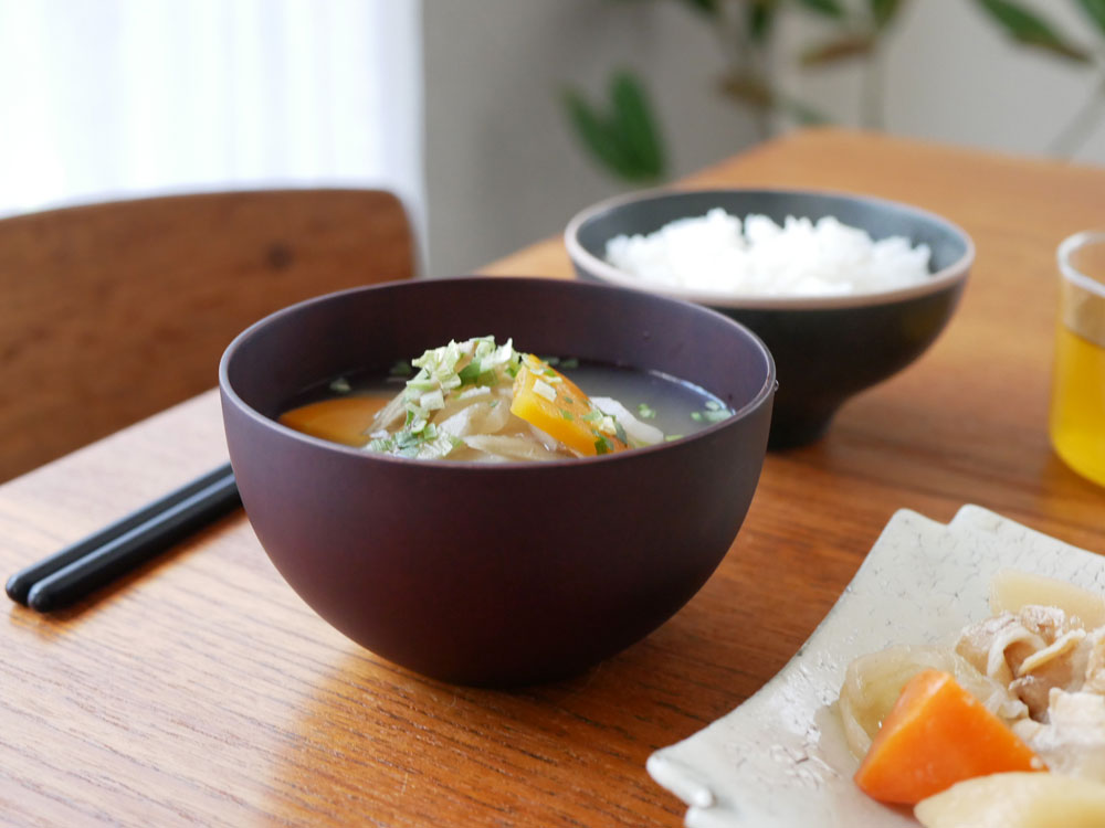 食洗機対応の天然木マルチボールに盛られたスープと野菜が並ぶ食卓のシーン