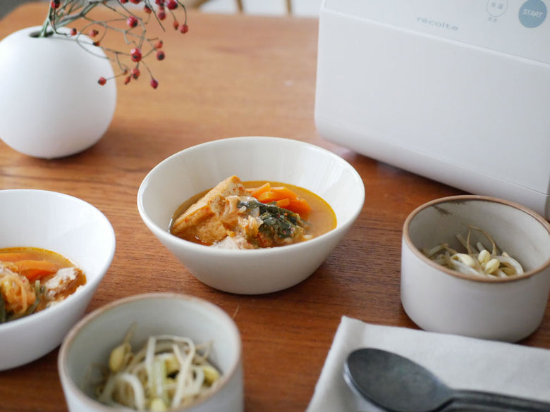 recolteのクッキングライスクッカーとご飯やおかずが盛り付けられた食卓の様子