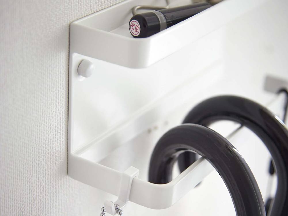 【smart/スマート】トレー付きアンブレラホルダー（シルバー）が石こうボード壁に取り付けられており、ハンガーやハンドルが見える