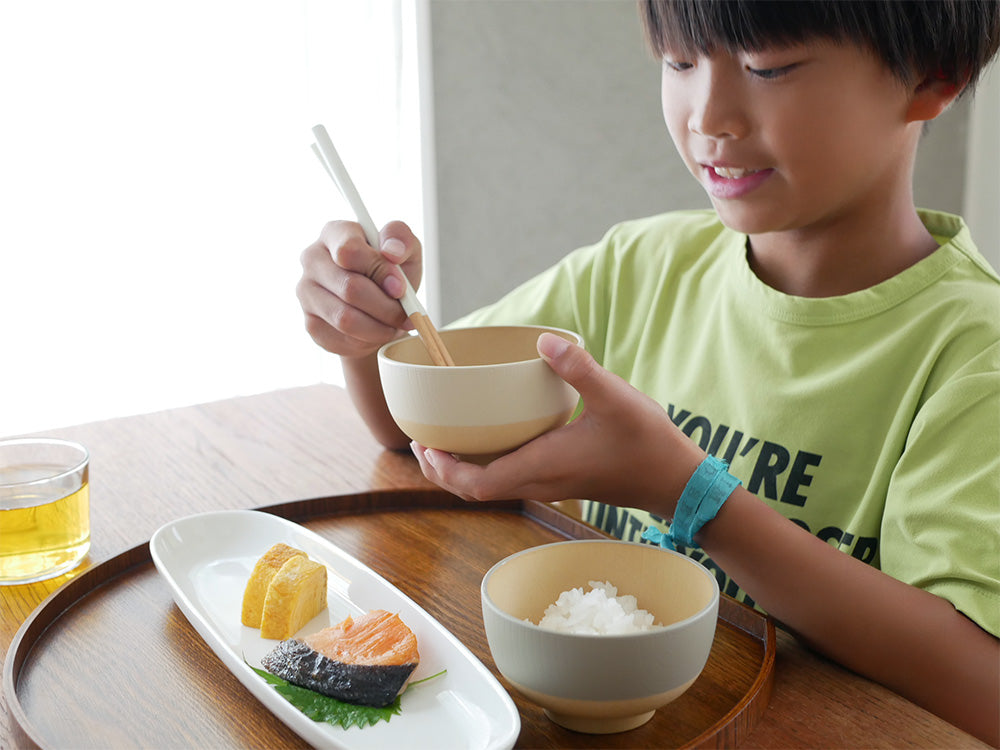 やさしい彩りシリーズの抗菌汁椀、抗菌丼、八角箸が木製のテーブルに美しく並べられた食器セットの写真