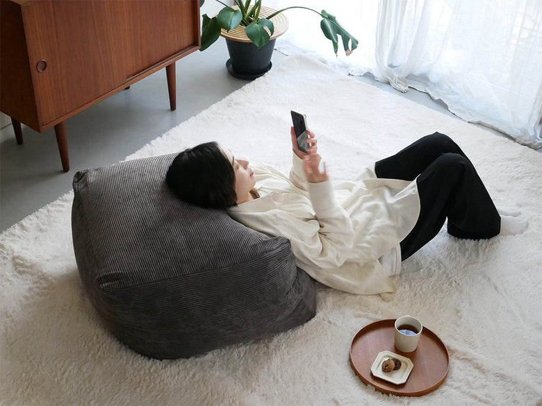 グレーのコーデュロイビーズクッションが置かれたリビングルームのソファ